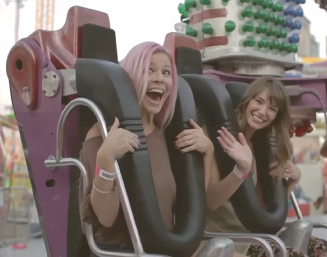 Two women about to ride on a carnival ride