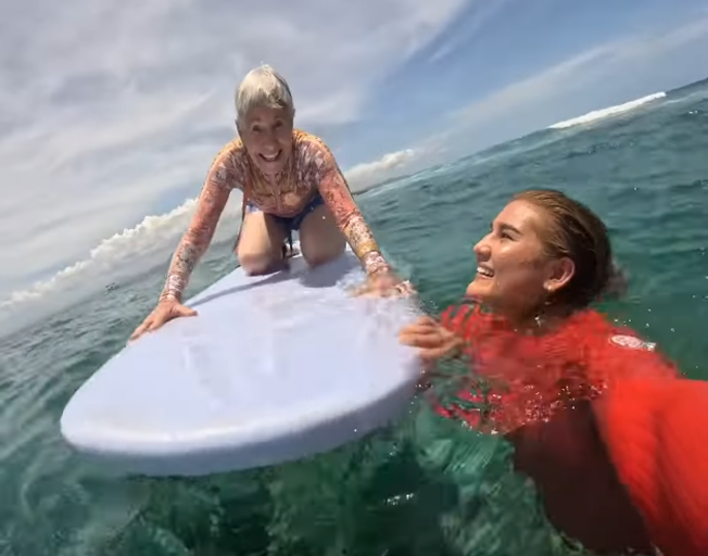 Donna on a surf board and her granddaughter Brisa Hennessy next to it